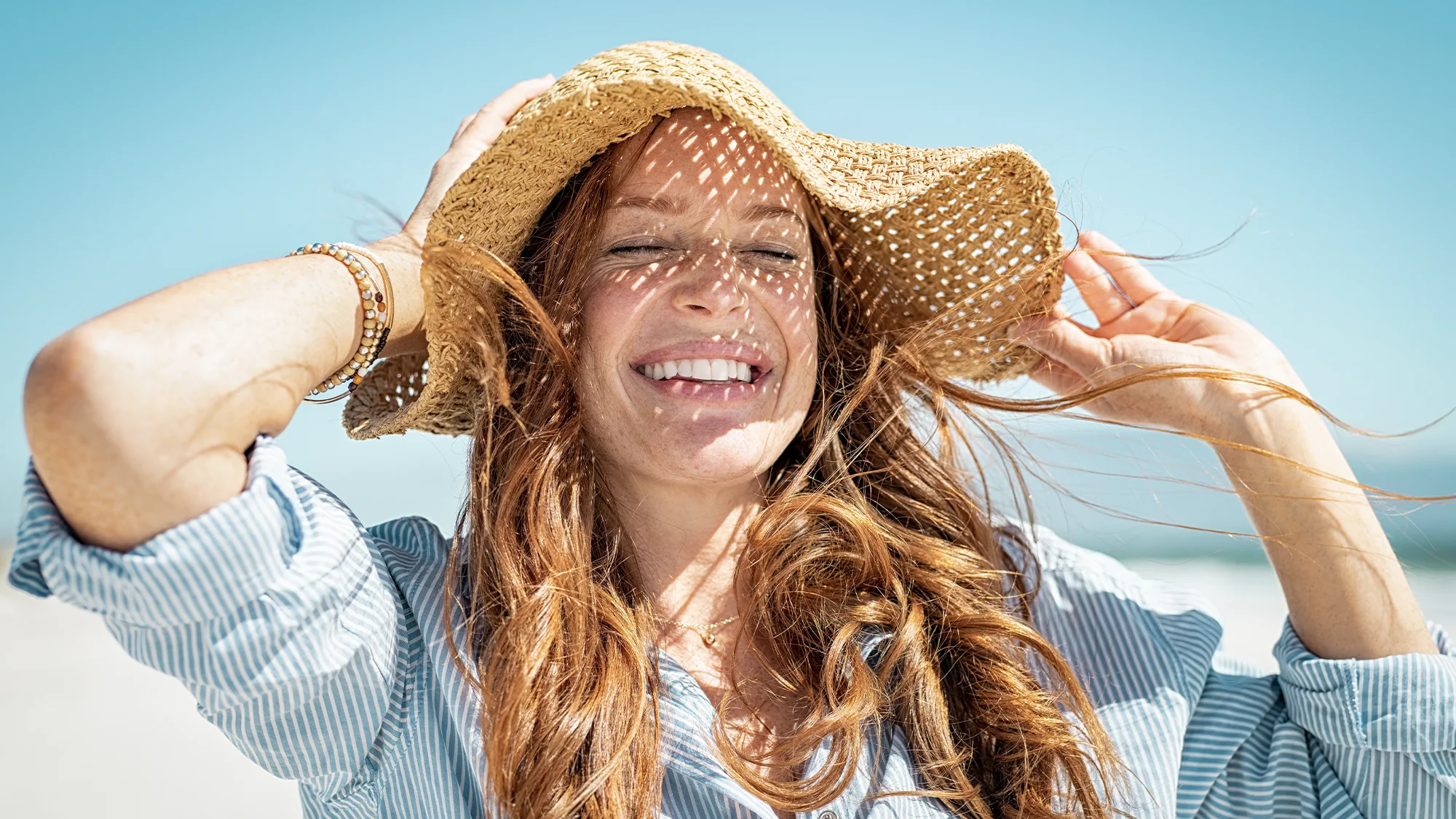 A woman with a sun hat smiles or something. SPF is your BFF... so true, bestie...